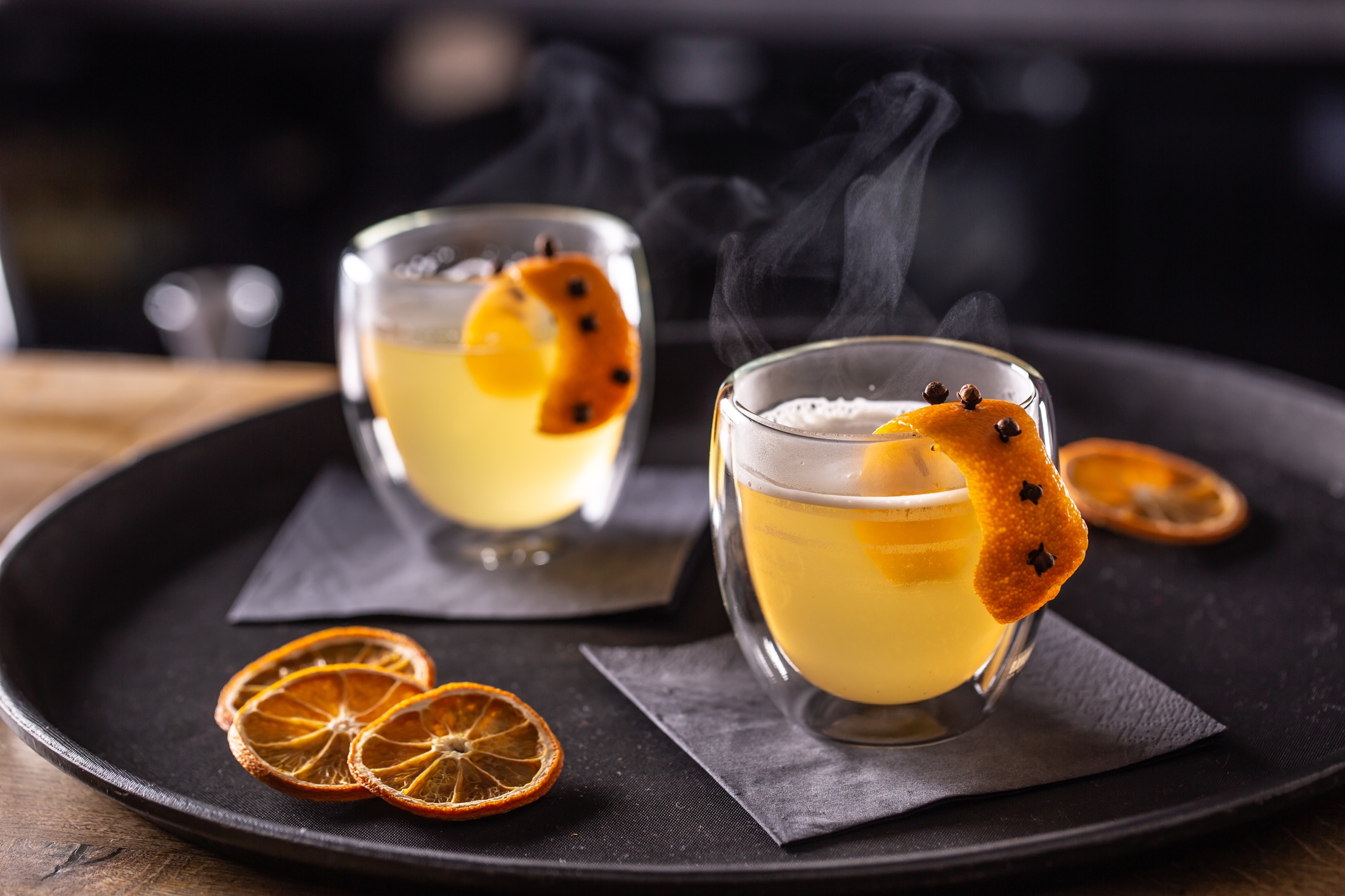 hot toddy drink made of whiskey simple syrup hot water cloves and orange zest ready for customers in the pub on the bar counter 236825333