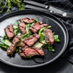 steak salad with spinach arugula and sliced beef striploin steak black background top view 190994259