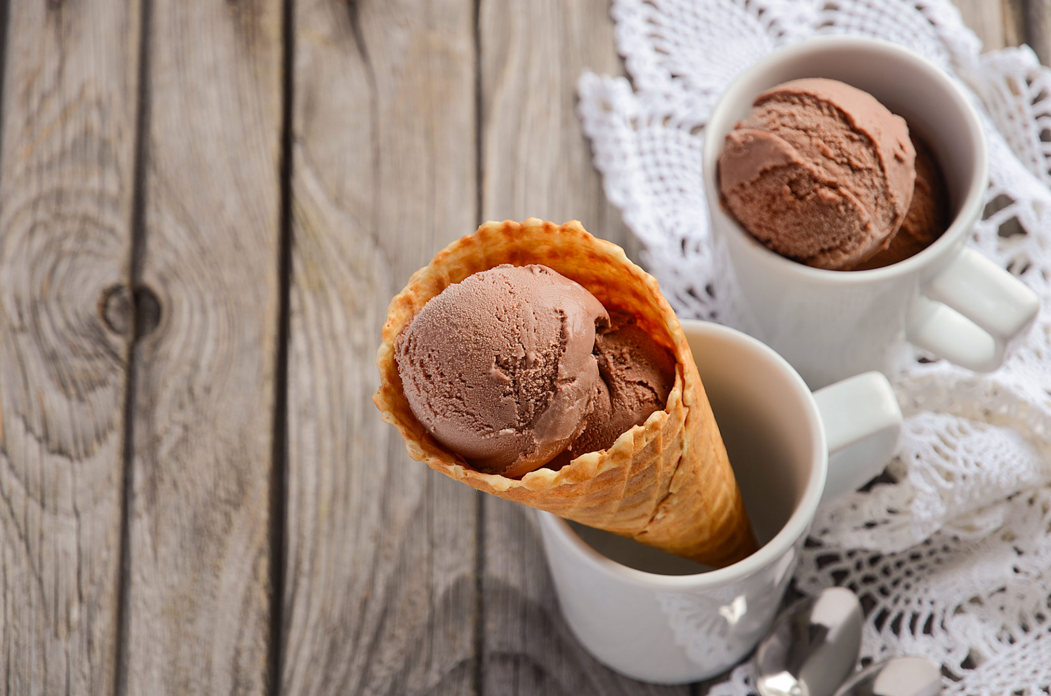 chocolate ice cream in waffle cone on rustic wooden background 69768003 scaled